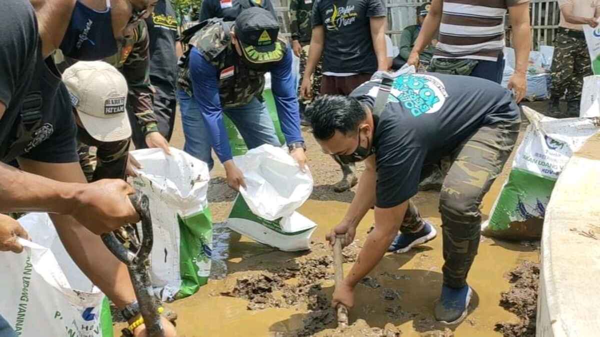 Ratusan Gerakan Pemuda Ansor Kraksaan Bersihkan Lumpur Sisa Banjir Dringu Probolinggo